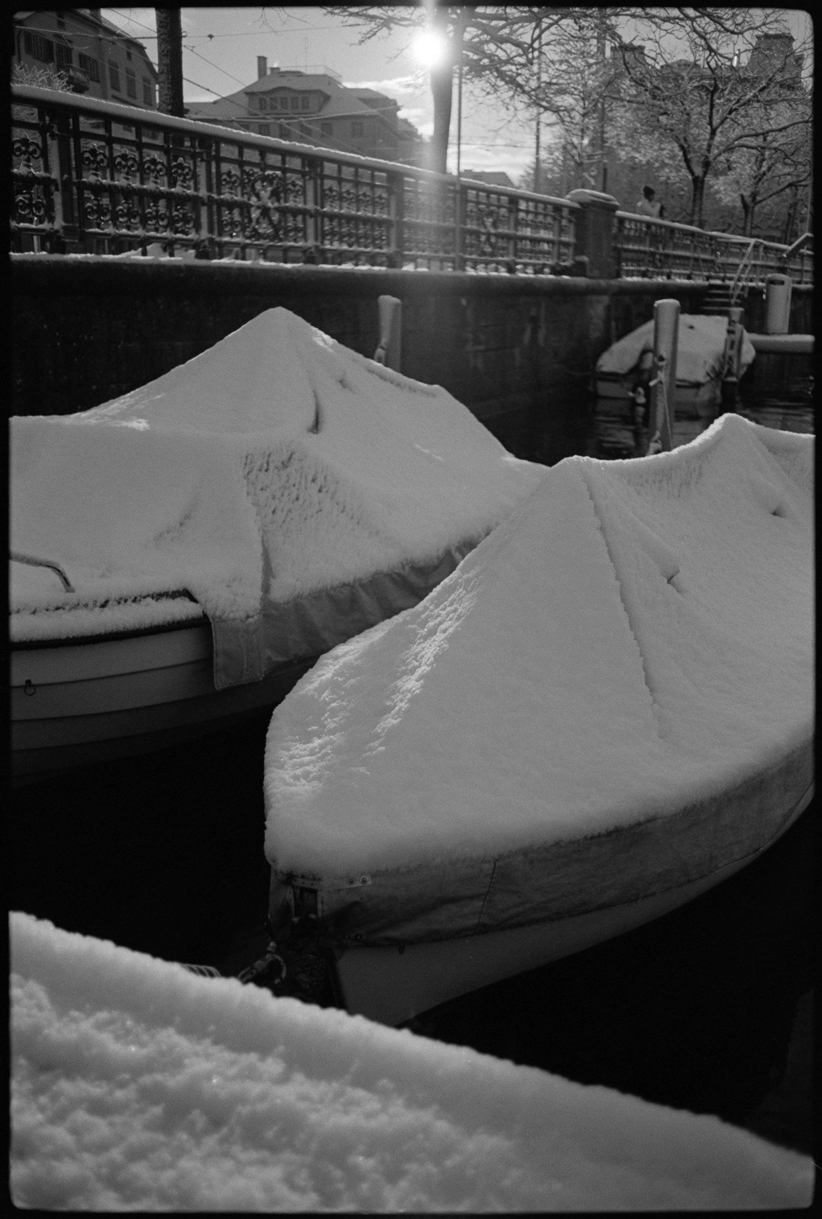 snow-covered boat with sun flare