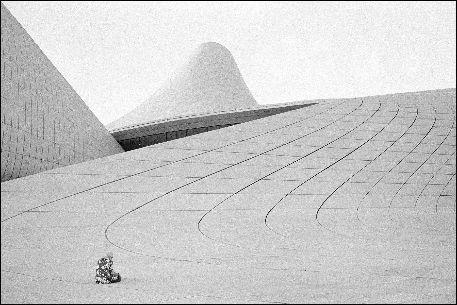 someone sitting in front of a modern building